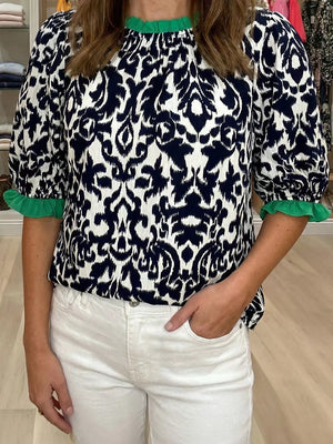 Damask print maternity blouse with green ruffled neckline and cuffs.