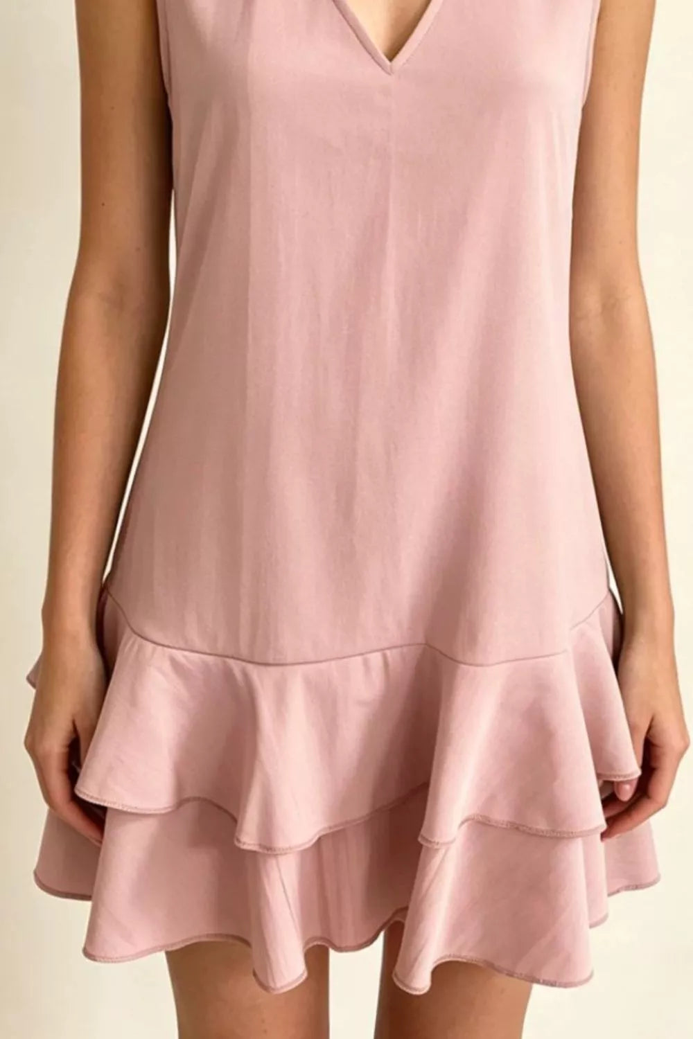 Dusty pink polyester mini dress with V-neck and tiered ruffle hem.
