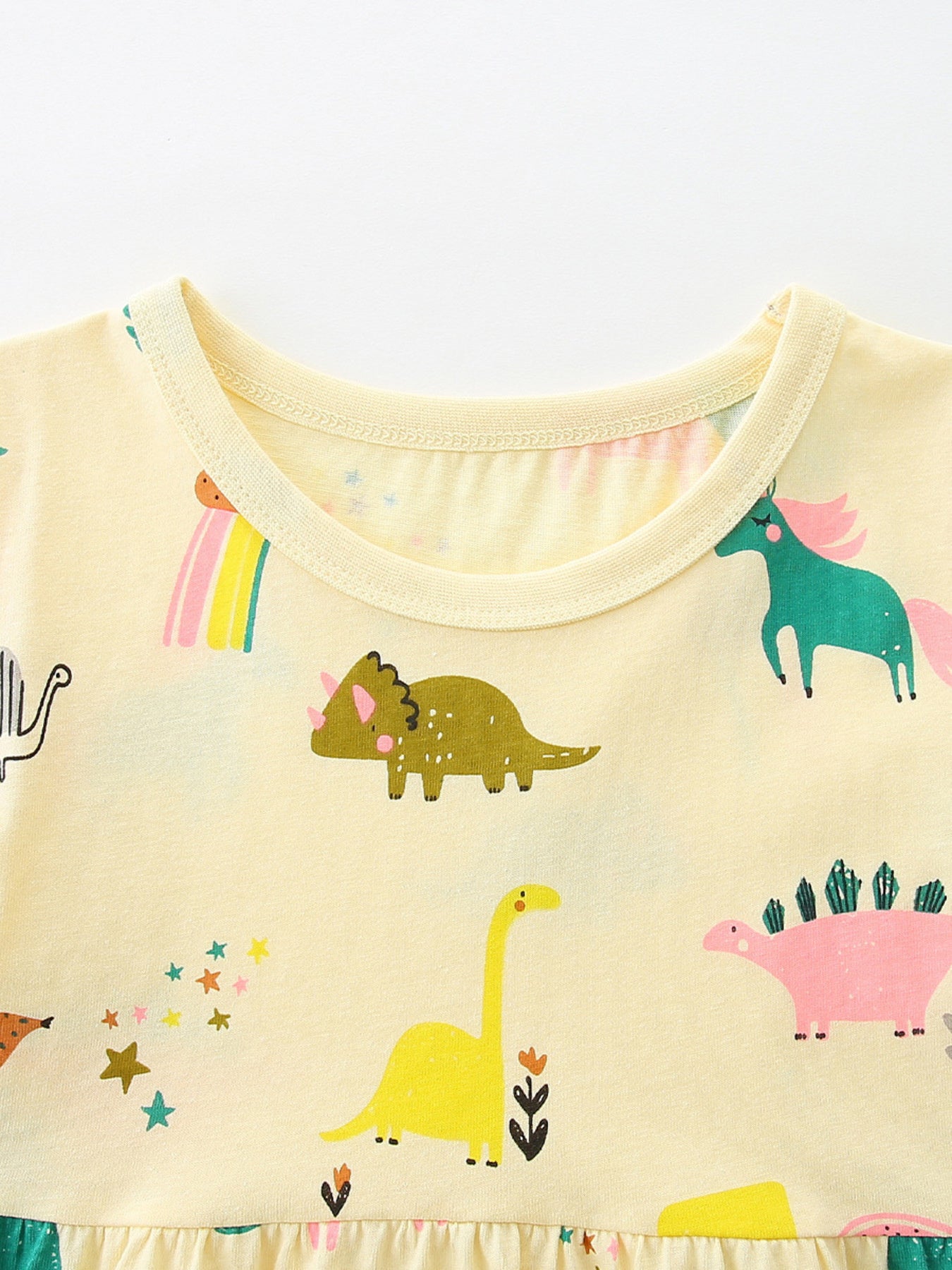 Yellow cotton toddler dress with whimsical dinosaur and unicorn print.