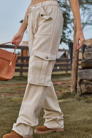Tan utility cargo pants with wide legs and buttoned flap pockets.