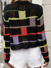 Black openwork knit sweater with colorful patchwork blocks and open knit details.