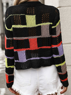 Black openwork knit sweater with colorful patchwork blocks and open knit details.