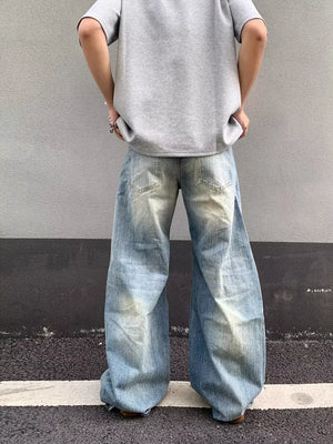 Distressed light wash denim wide-leg jeans with pocket detail.
