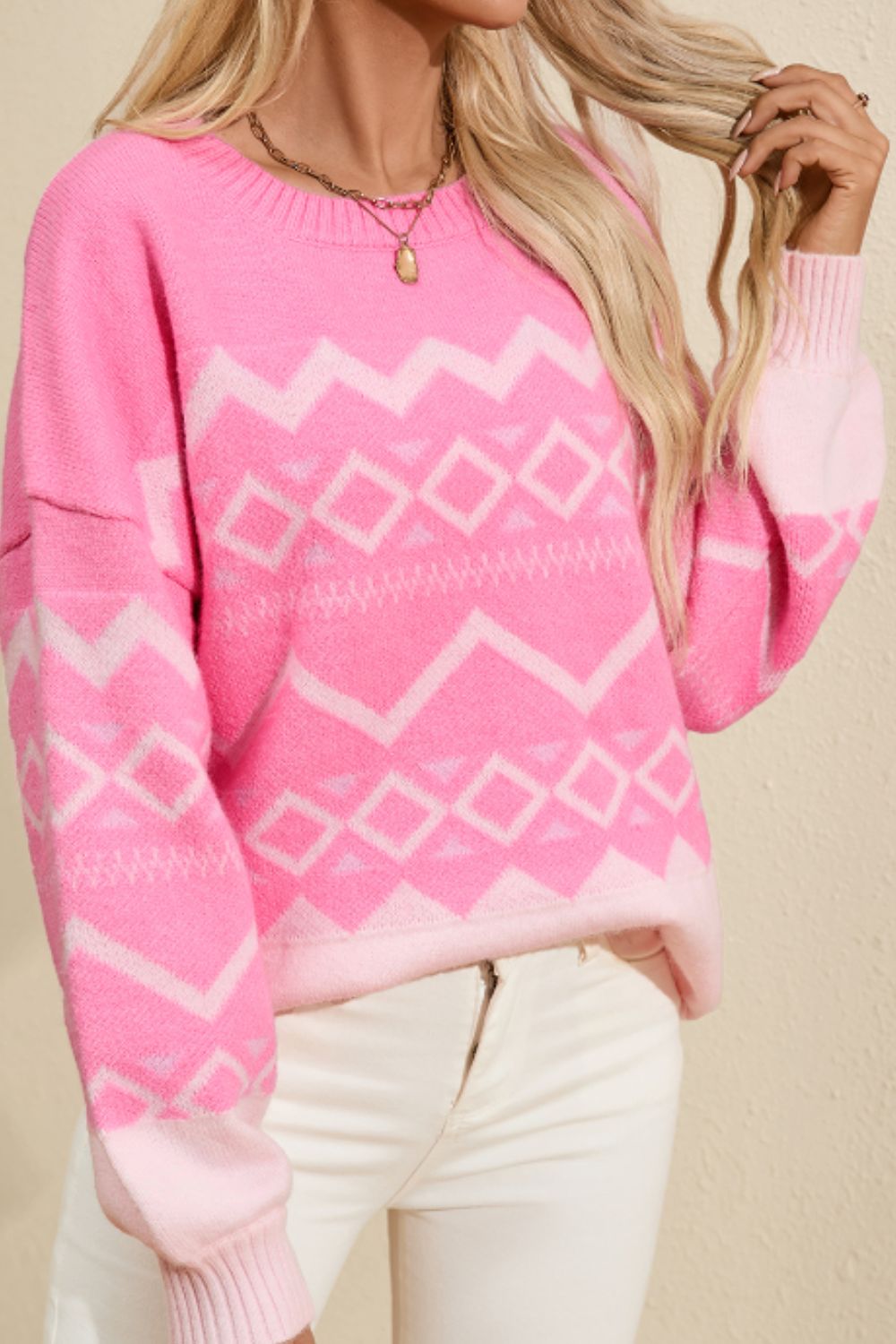 Pink geometric knit sweater with diamond and chevron patterns, crewneck, long sleeves, acrylic blend.