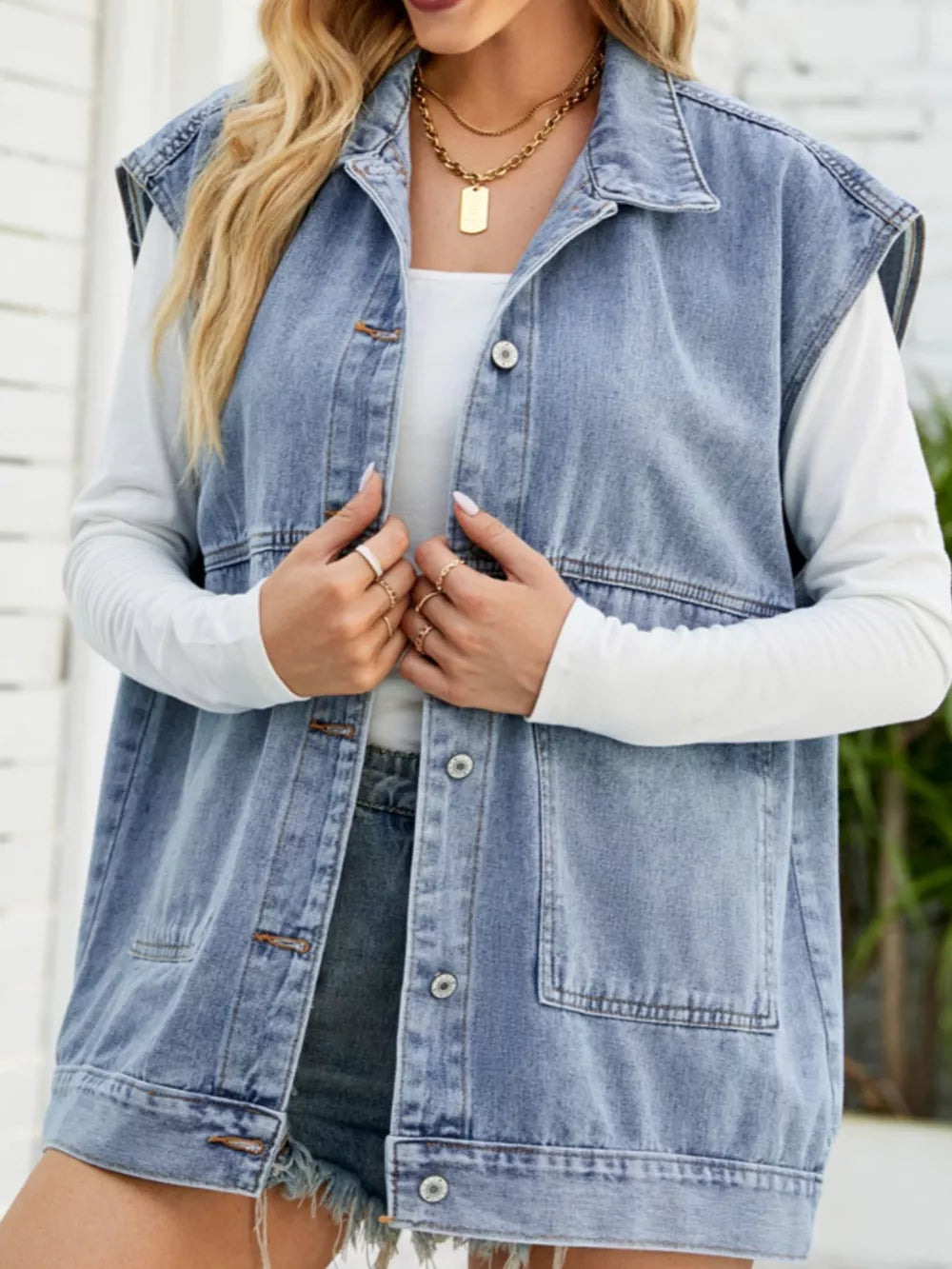 Light blue sleeveless denim vest with button-down front and chest pockets.