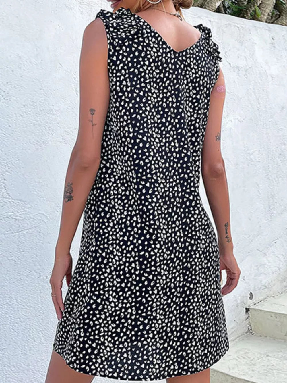 Black leopard print mini dress with frill detail on shoulders.