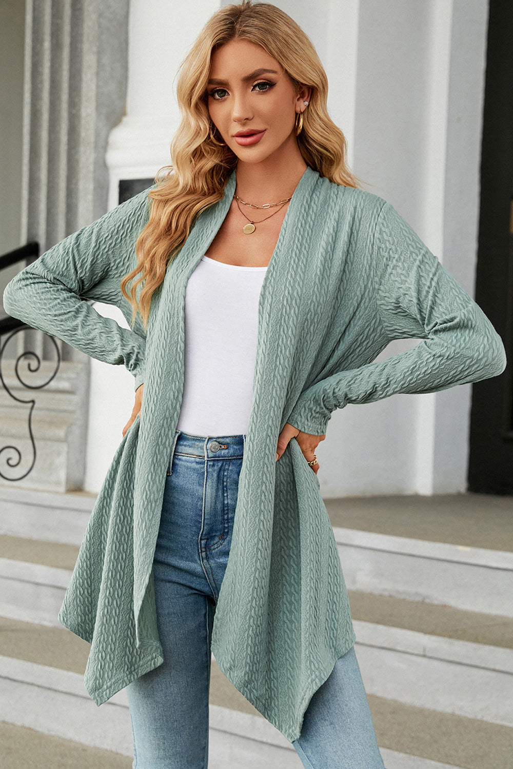 Light green textured knit cardigan with asymmetrical drape front and long sleeves.