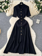 Black knit Peter Pan collar dress with gold buttons and short sleeves.