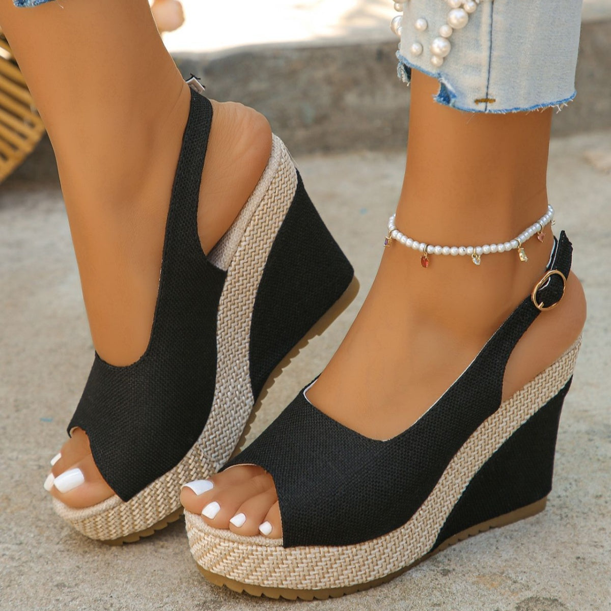 Black woven espadrille wedge sandals with peep toe and slingback strap.