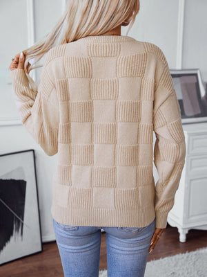 Cream textured checkerboard knit pullover sweater with ribbed details.