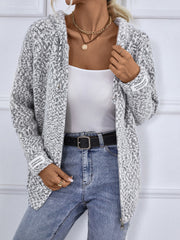 Textured knit zip-up cardigan in charcoal with a subtle geometric pattern and logo detail on the sleeve.