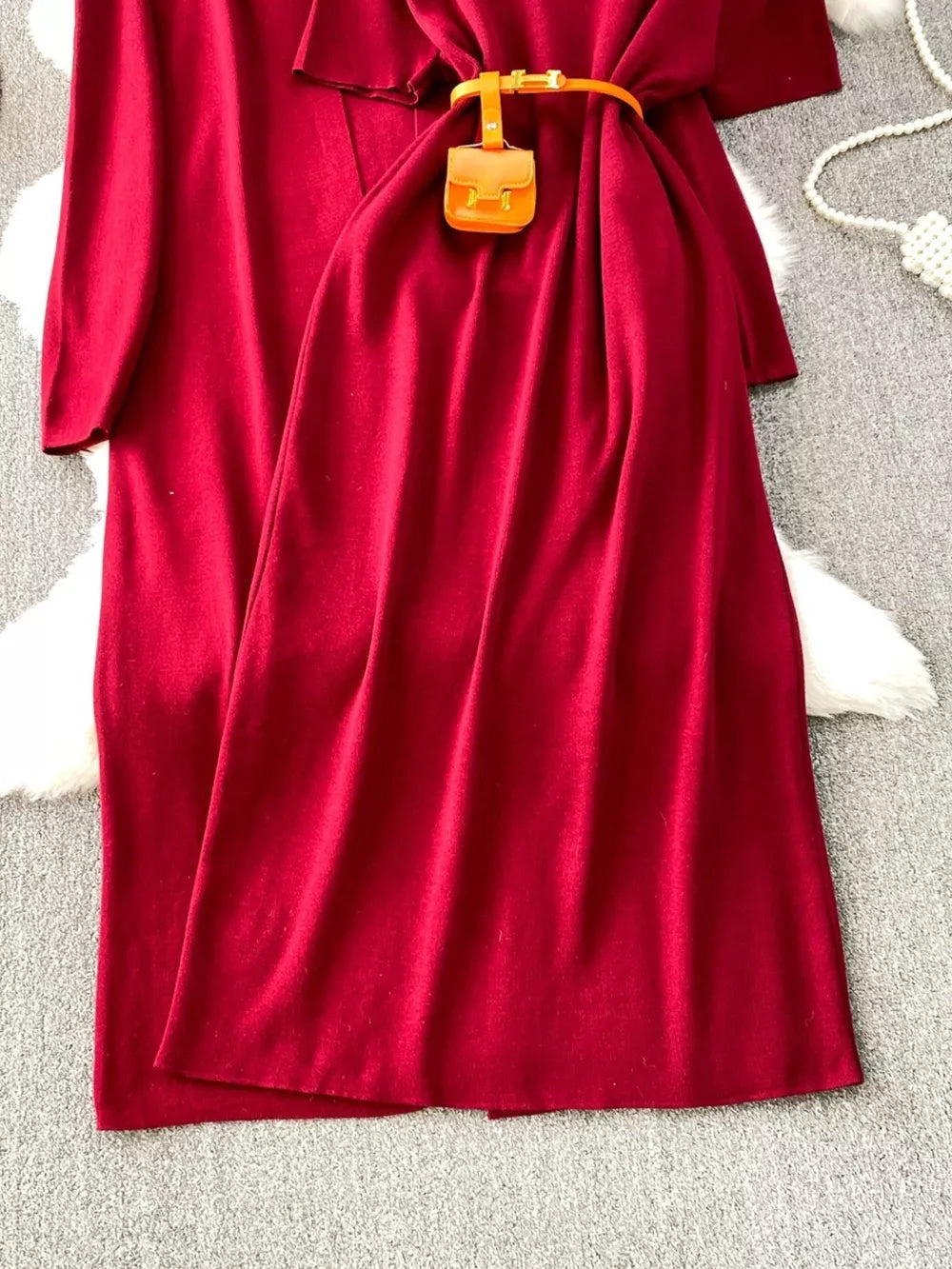 Burgundy knitted maxi dress and cardigan ensemble with belt and mini bag detail.
