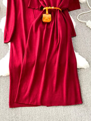 Burgundy knitted maxi dress and cardigan ensemble with belt and mini bag detail.