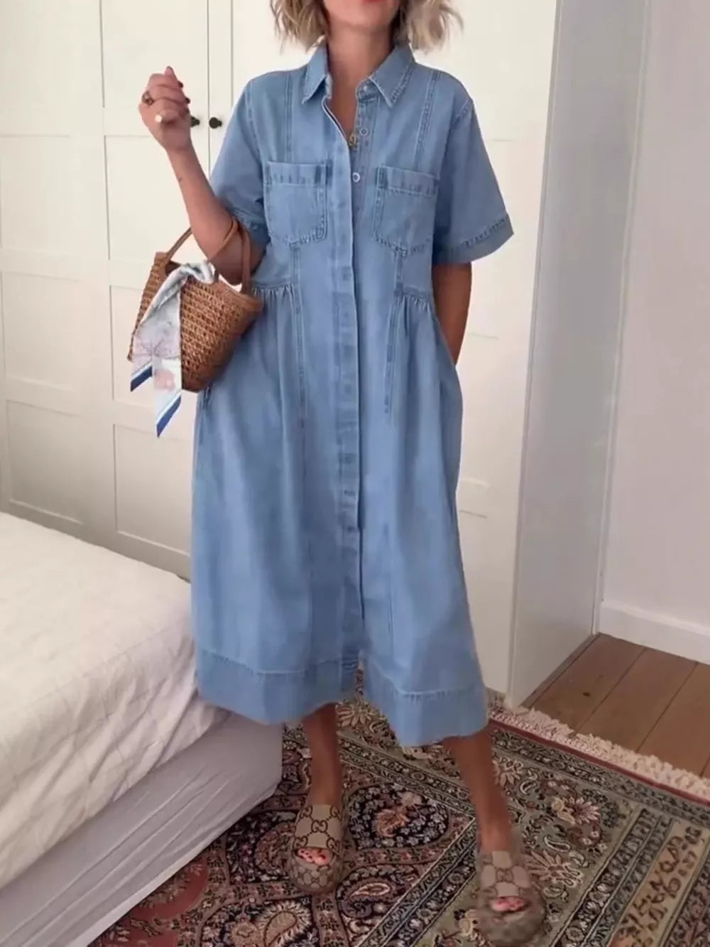 Denim midi dress with short sleeves, collared neckline, button front, and chest pockets.