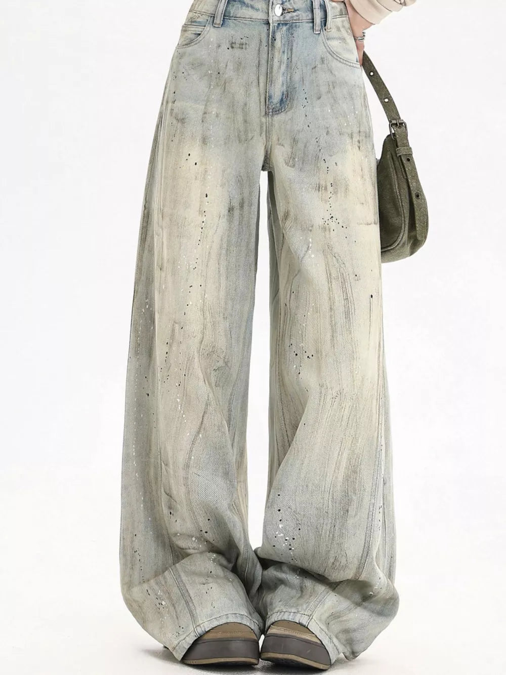 Light vintage wash wide-leg denim jeans with distressed paint splatter details.