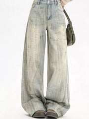 Light vintage wash wide-leg denim jeans with distressed paint splatter details.