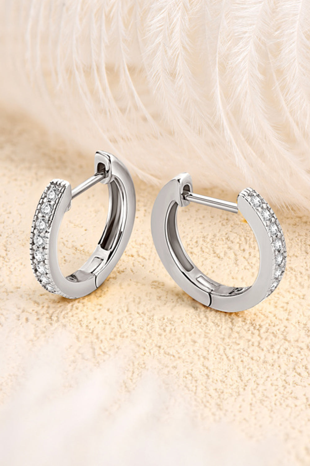 Silver pave-set huggie hoop earrings with sparkling stones.