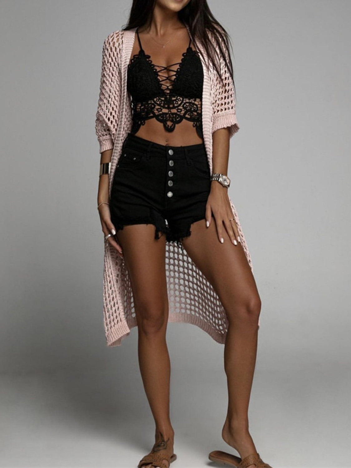 Open-knit duster cardigan in Apricot with short sleeves and a long hem, styled with a lace bralette and denim shorts.