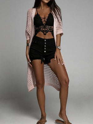Open-knit duster cardigan in Apricot with short sleeves and a long hem, styled with a lace bralette and denim shorts.