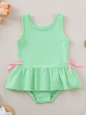 Green striped seersucker one-piece swimsuit with ruffled hem and pink side bows.