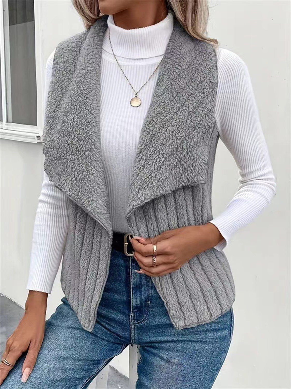 Gray textured teddy collarless vest with ribbed knit detail and open front.