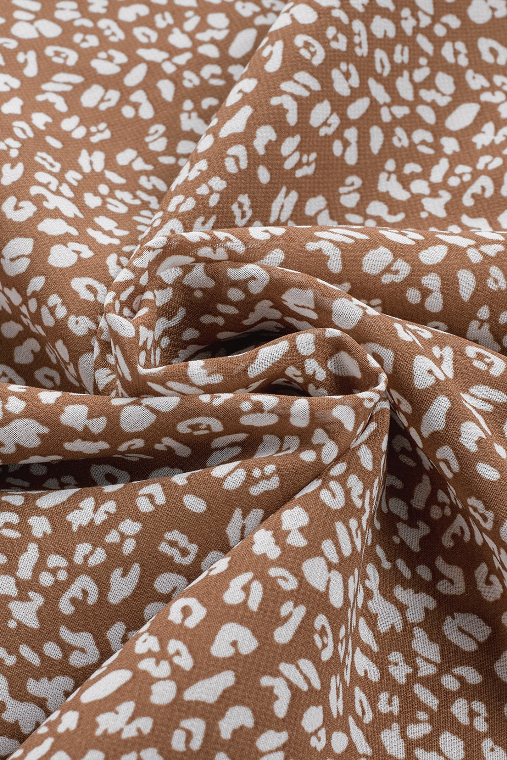 Brown sleeveless blouse with white leopard print and ruffled neckline detail.