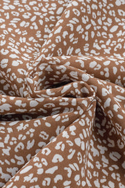 Brown sleeveless blouse with white leopard print and ruffled neckline detail.