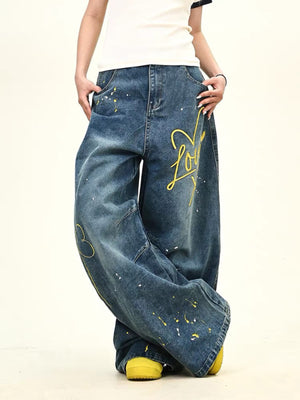Oversized blue wide-leg jeans with yellow love graphic and paint splatters