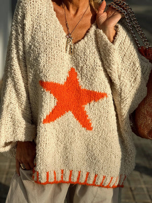 Cream knit v-neck pullover with orange star and striped hem detail.