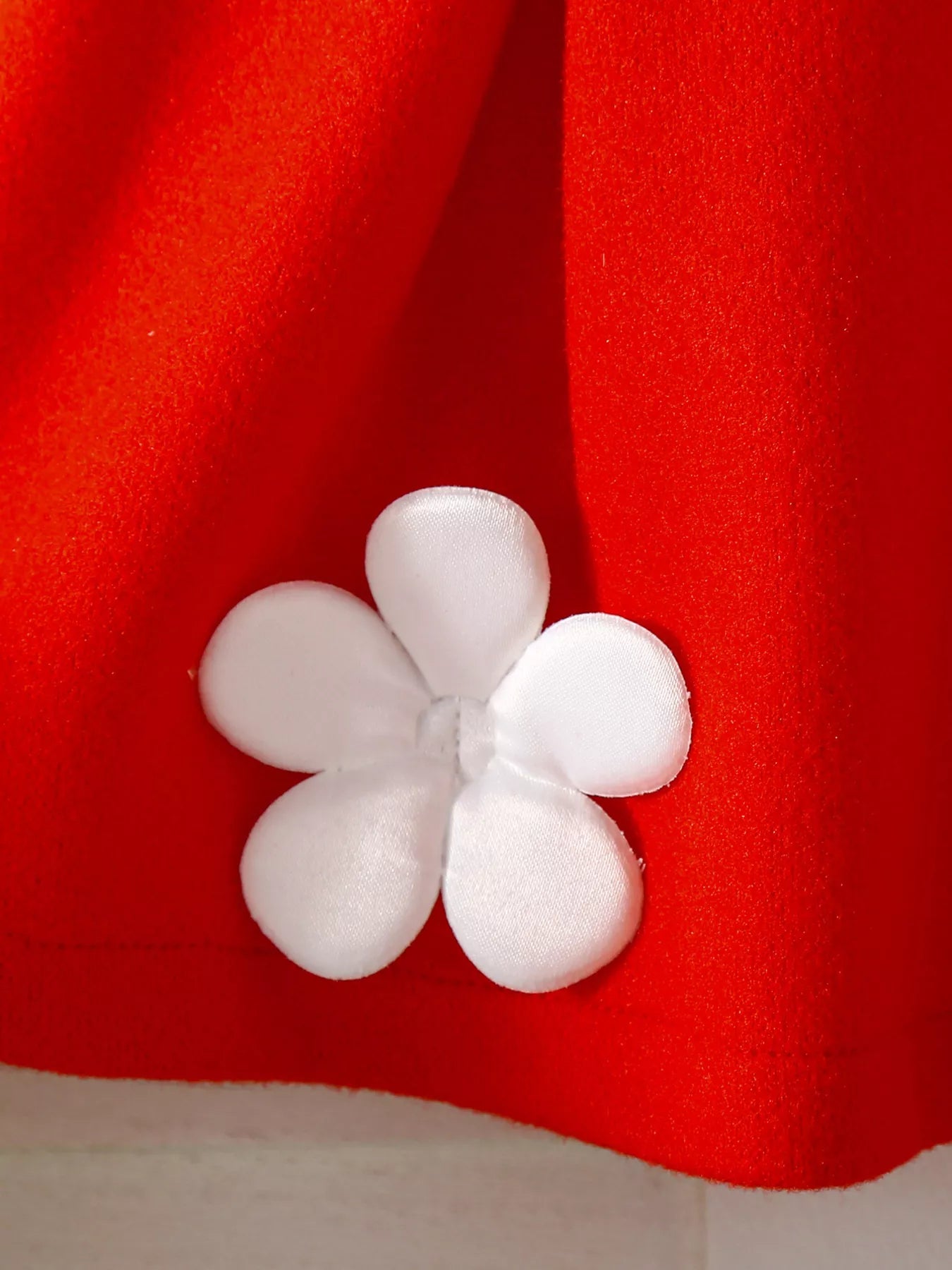 Red knit baby outfit with white floral applique detail.
