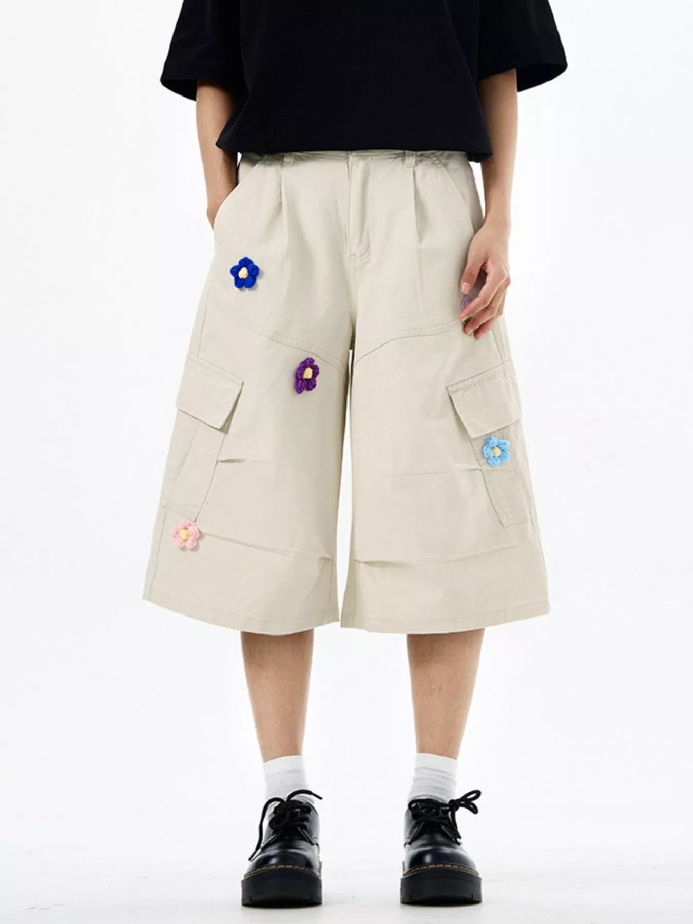 Tan cotton cargo shorts with floral appliques and wide legs.