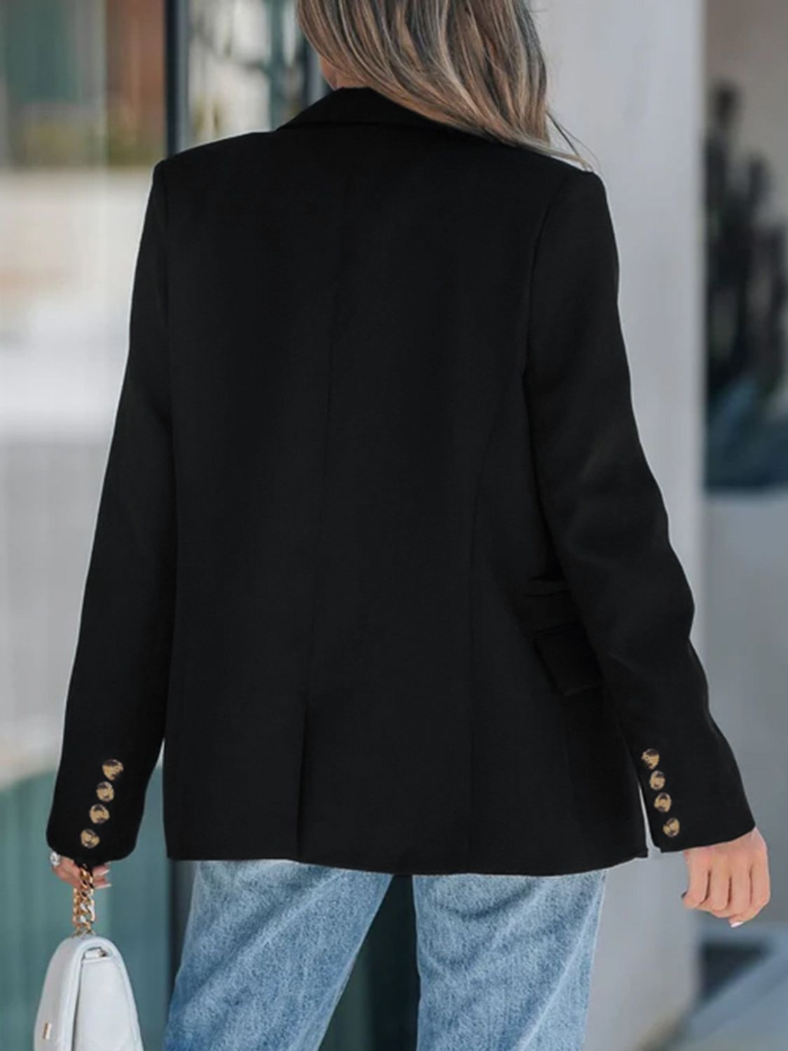 Black double-breasted blazer with gold buttons on cuffs and a sculpted fit.
