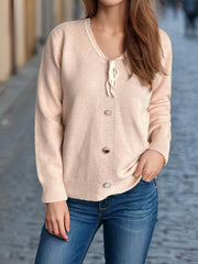 Ribbon-trimmed button-front knit cardigan in light pink with tie detail and silver buttons.