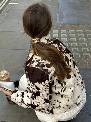 Buttoned collared jacket in cow print with a mesh hem detail.