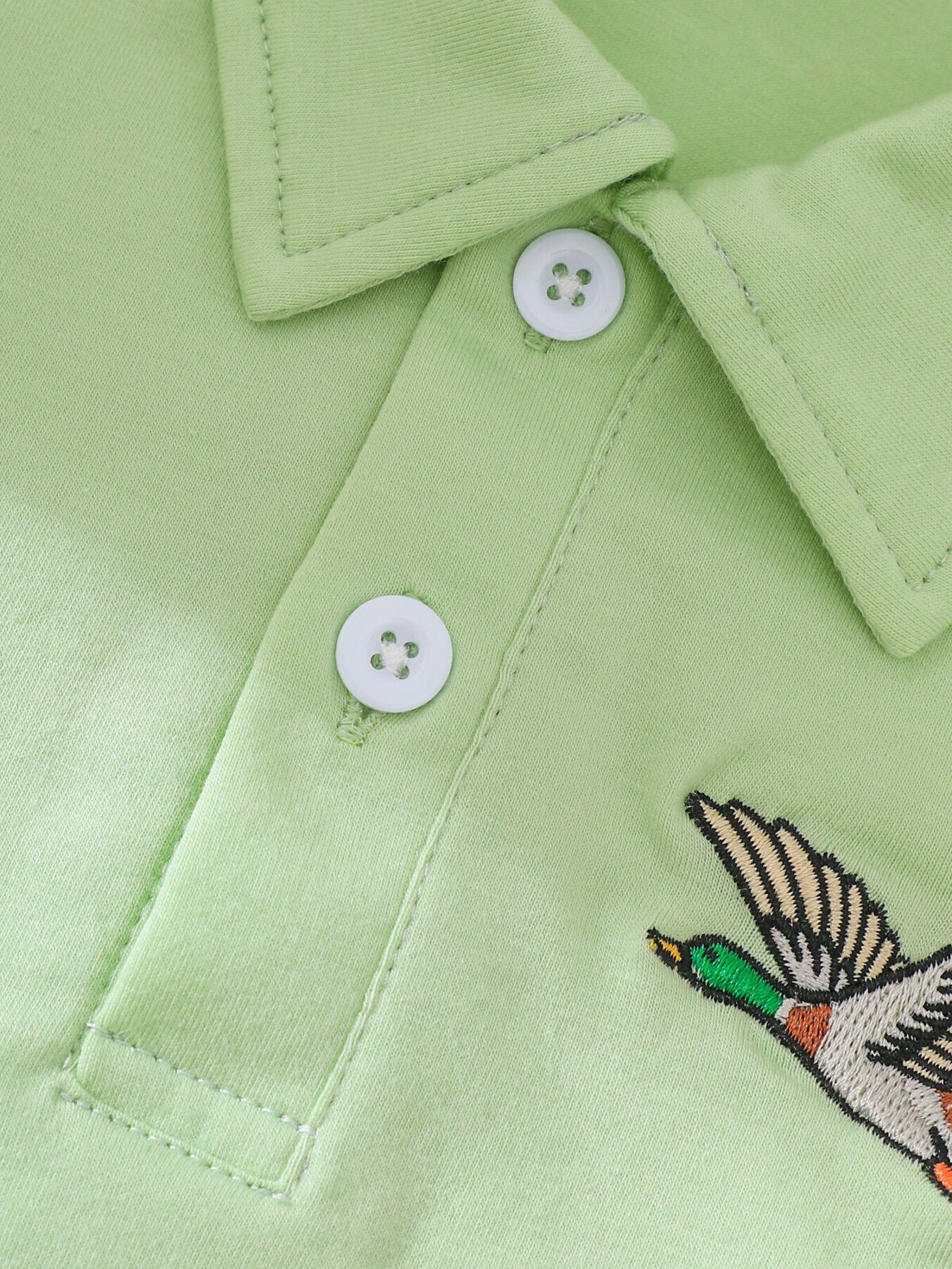 Light green cotton polo shirt with embroidered duck detail and white buttons
