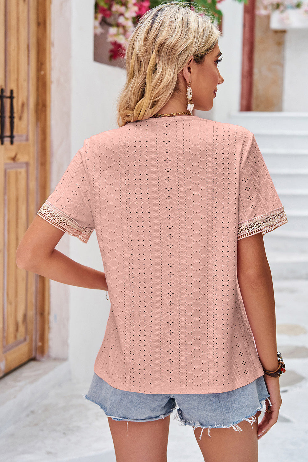 Blush pink eyelet blouse with lace trim on short sleeves and V-neck.
