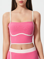 Fuchsia pink contour-trimmed crop top with white piping and sculpted bust detail.