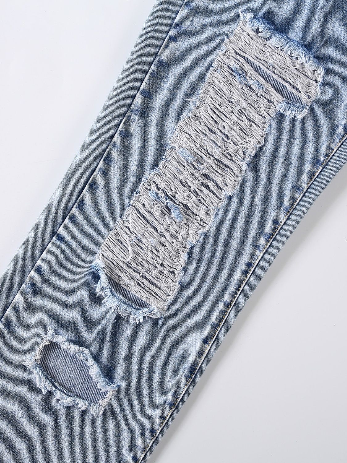 Light wash denim jeans with shredded knee detail and distressed rips.