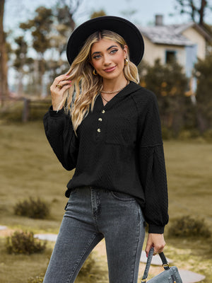 Black textured knit henley hoodie with balloon sleeves and button detail