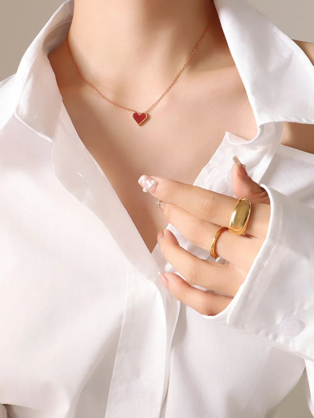 Crimson heart pendant necklace on rose gold chain, 18K gold detail, worn with white shirt
