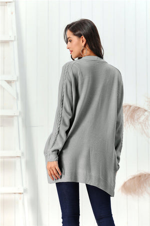 Gray cable knit open front cardigan with braided sleeve detail.