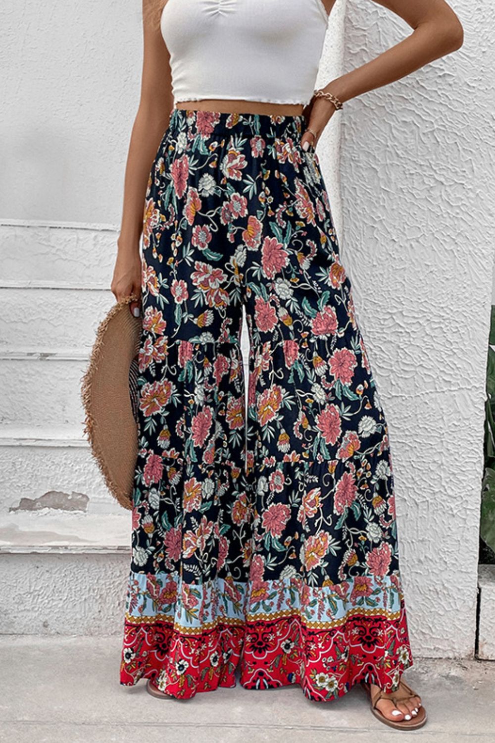 Floral border palazzo trousers with a high waist and wide leg, featuring a dark floral print and a colorful border hem.