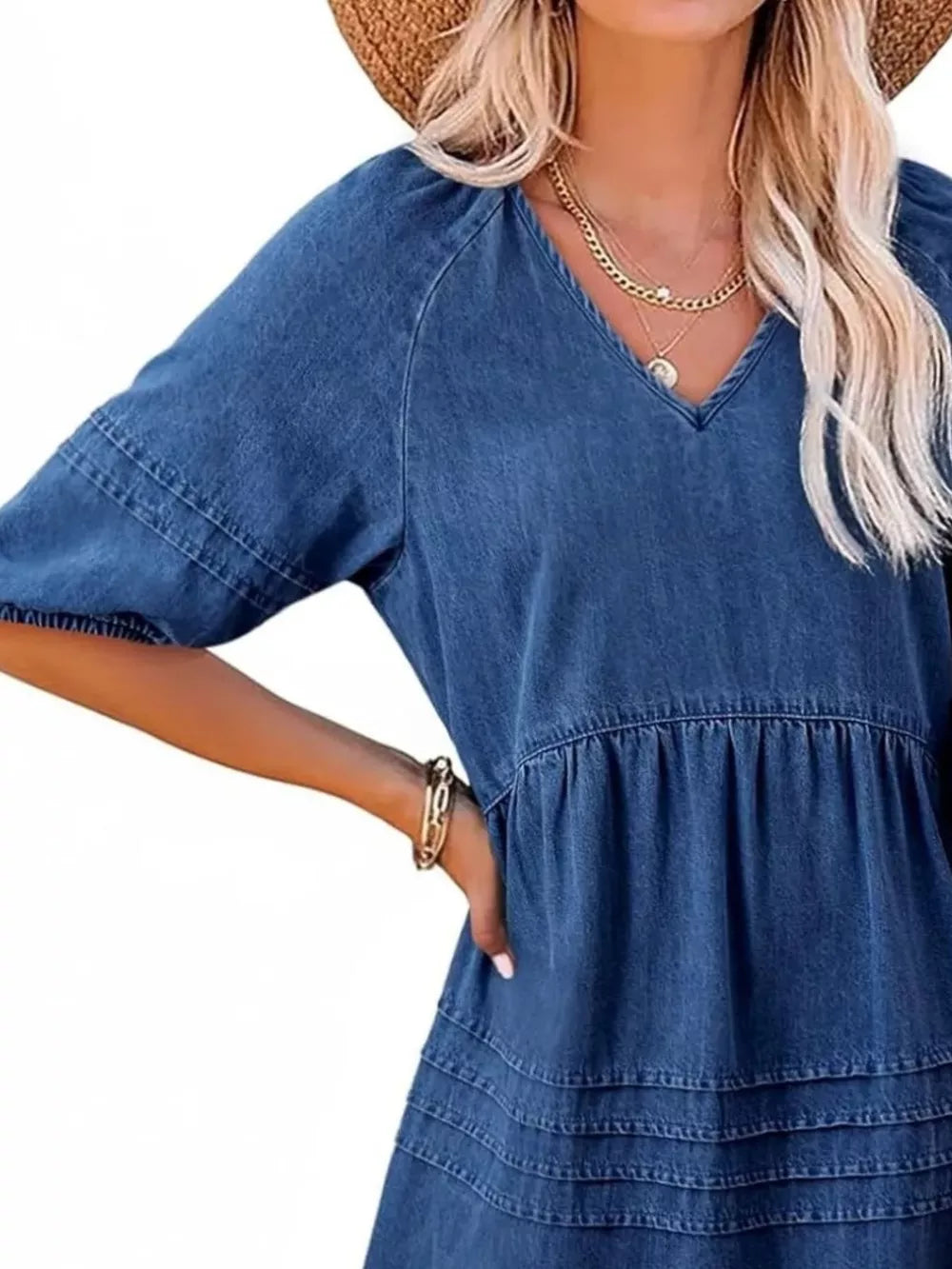 Denim mini dress with puff sleeves, V-neck, and tiered skirt.