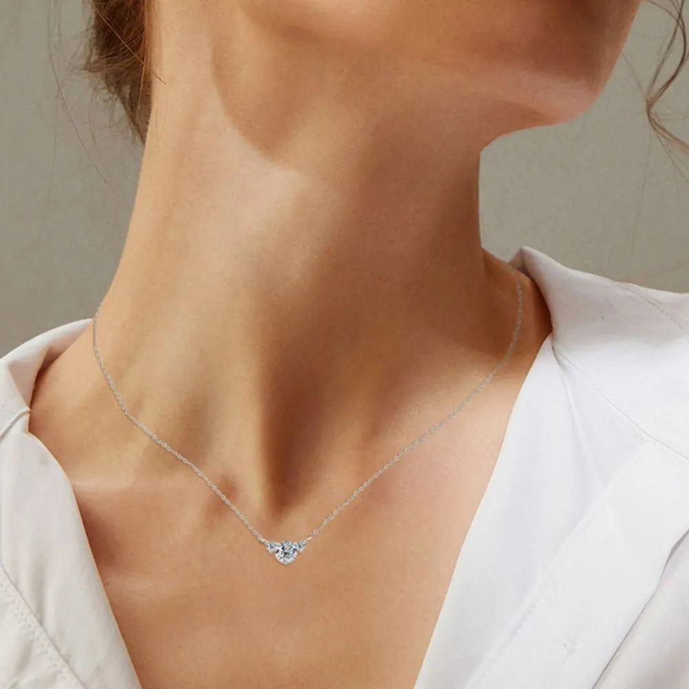Silver necklace with a trio of clear diamonds in a crescent shape.