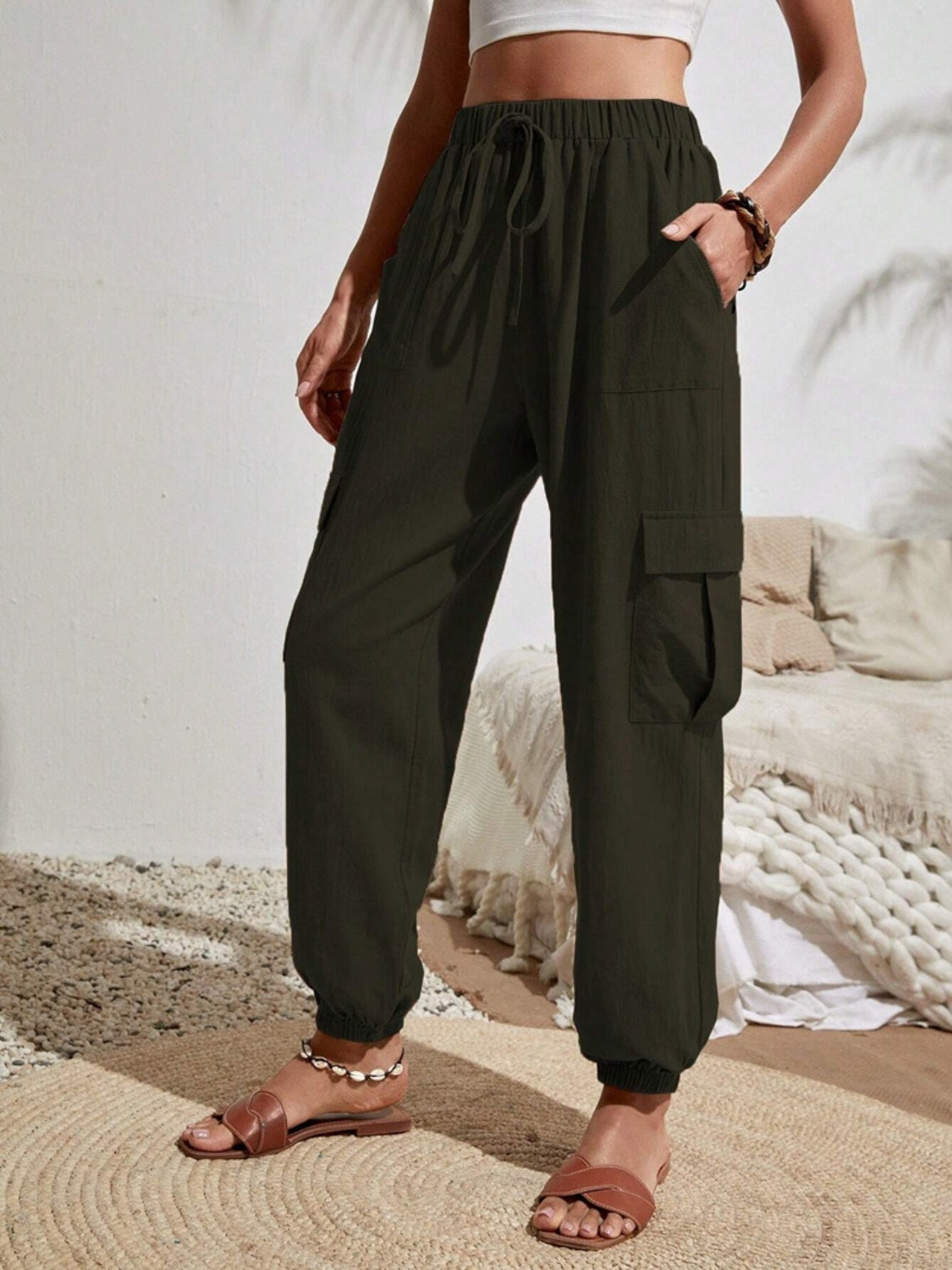 Dark green textured cargo lounge trousers with drawstring waist and cuffed ankles.