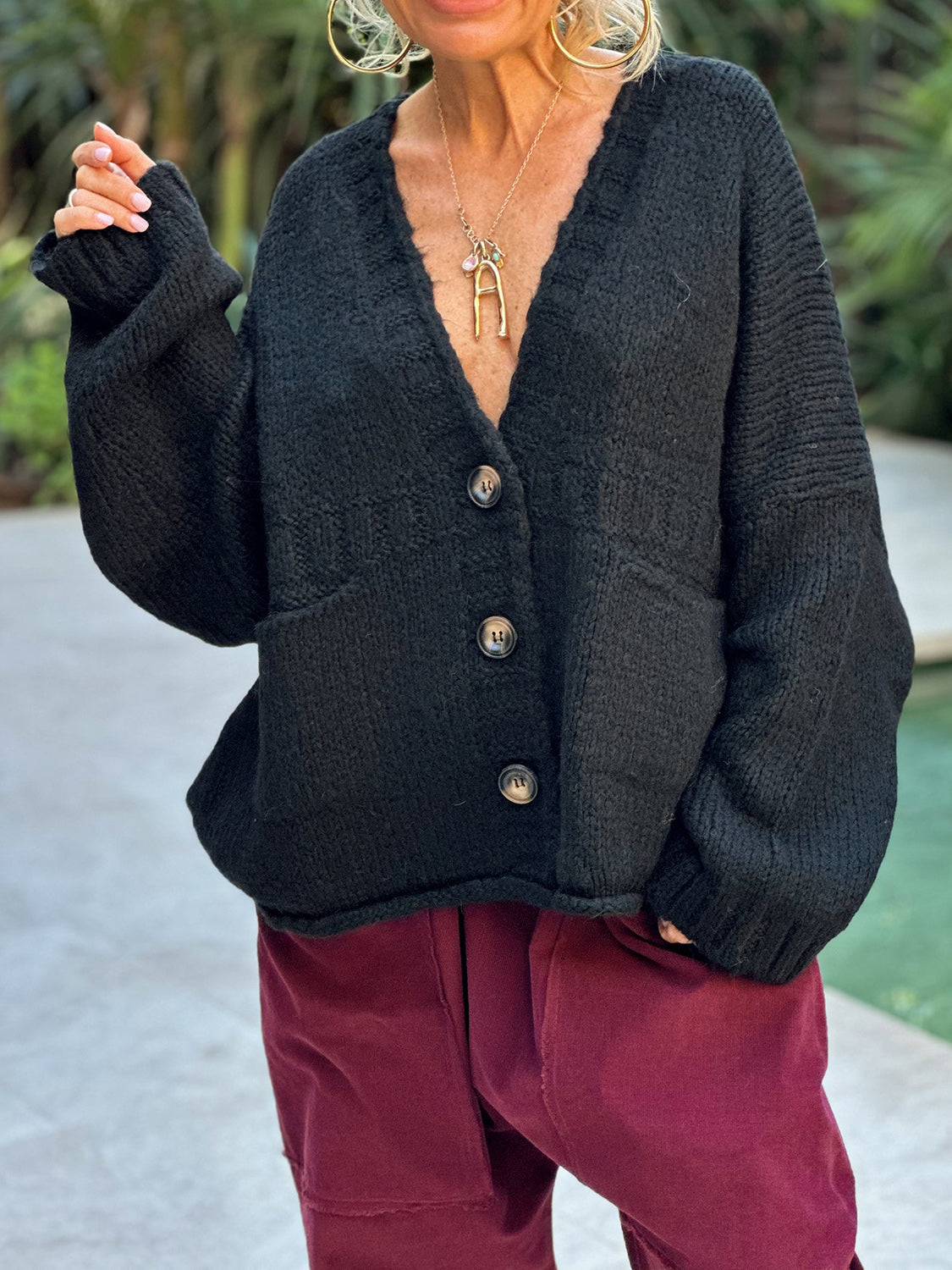 Black knit bouclé oversized button-down cardigan with V-neck and patch pockets.