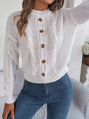 White cable knit button-up sweater with tortoiseshell buttons and open knit details.