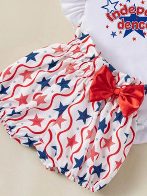 Baby outfit set with white top and bloomer shorts featuring red and blue stars and wavy lines, red bow detail