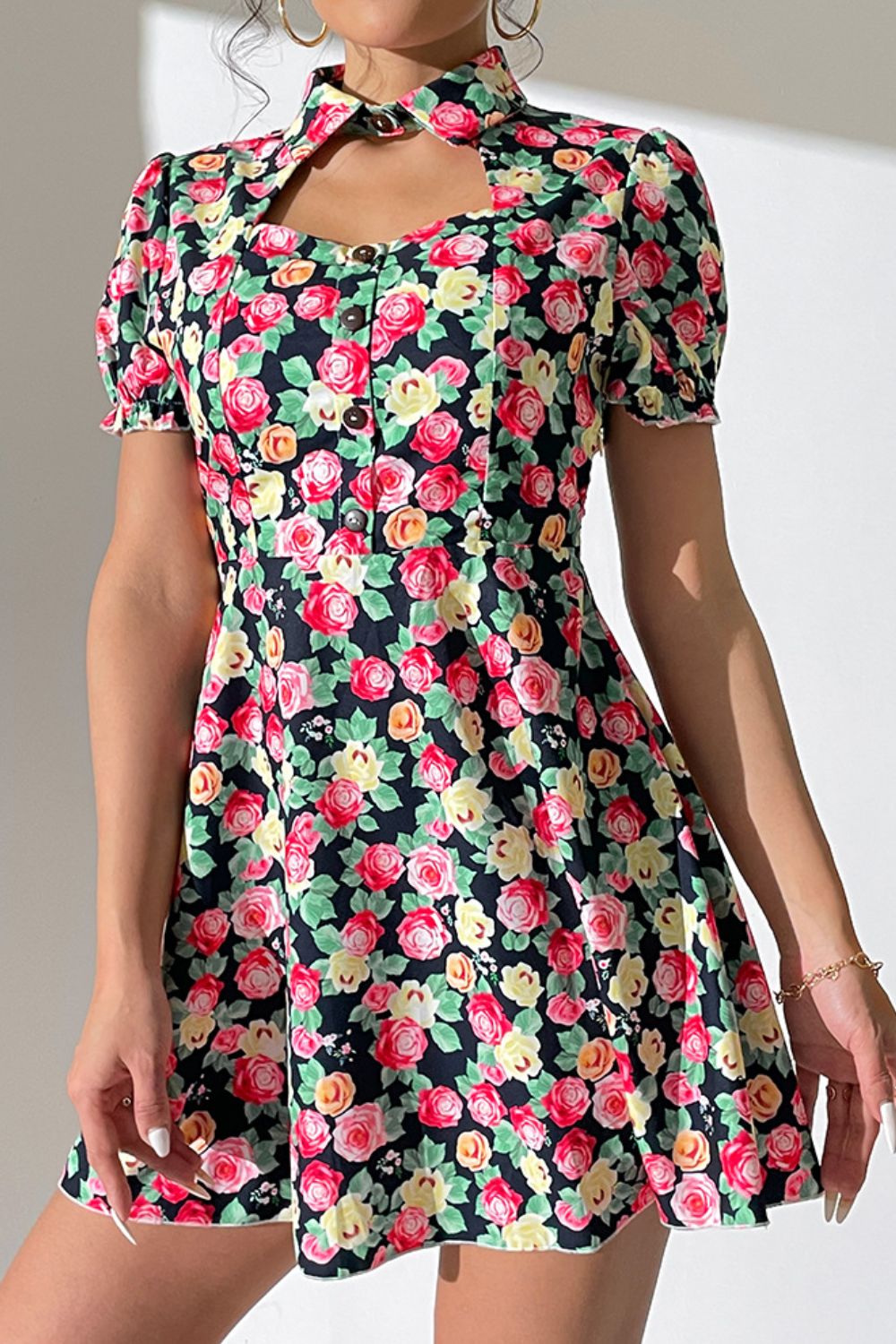 Floral mini dress with keyhole neckline, puff sleeves, and button front.