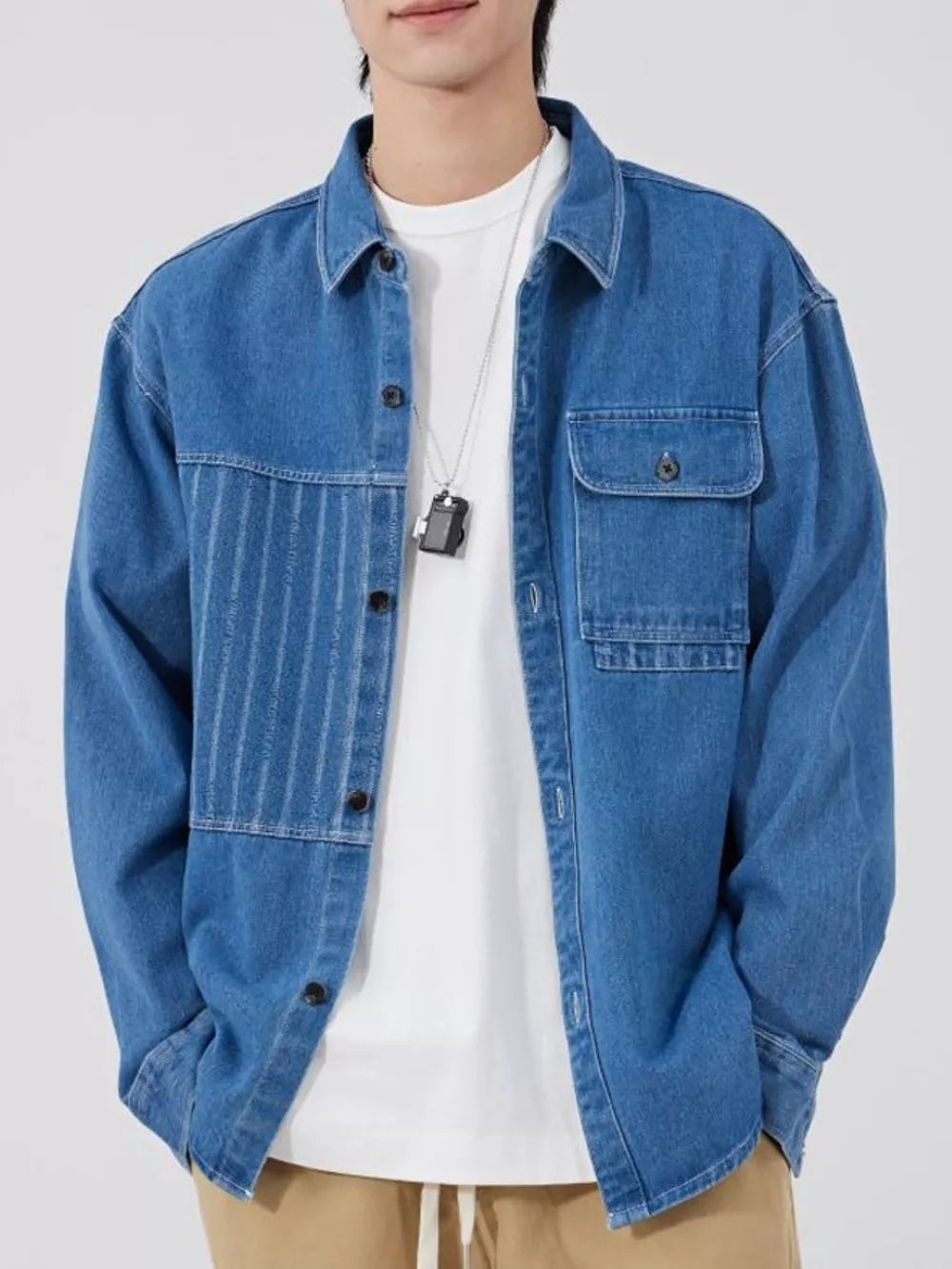Men's light blue denim overshirt with chest pocket and vertical stripe detail.